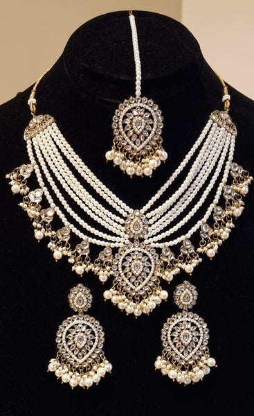 Designer kundan and pearl layered rani haar with earrings and tikka.