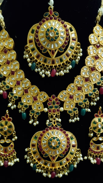 Red & green kundan moti necklace set with earrings and tikka.