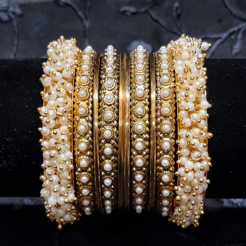 Gold metal bangles set with ivory and golden kangan bangles with pearls