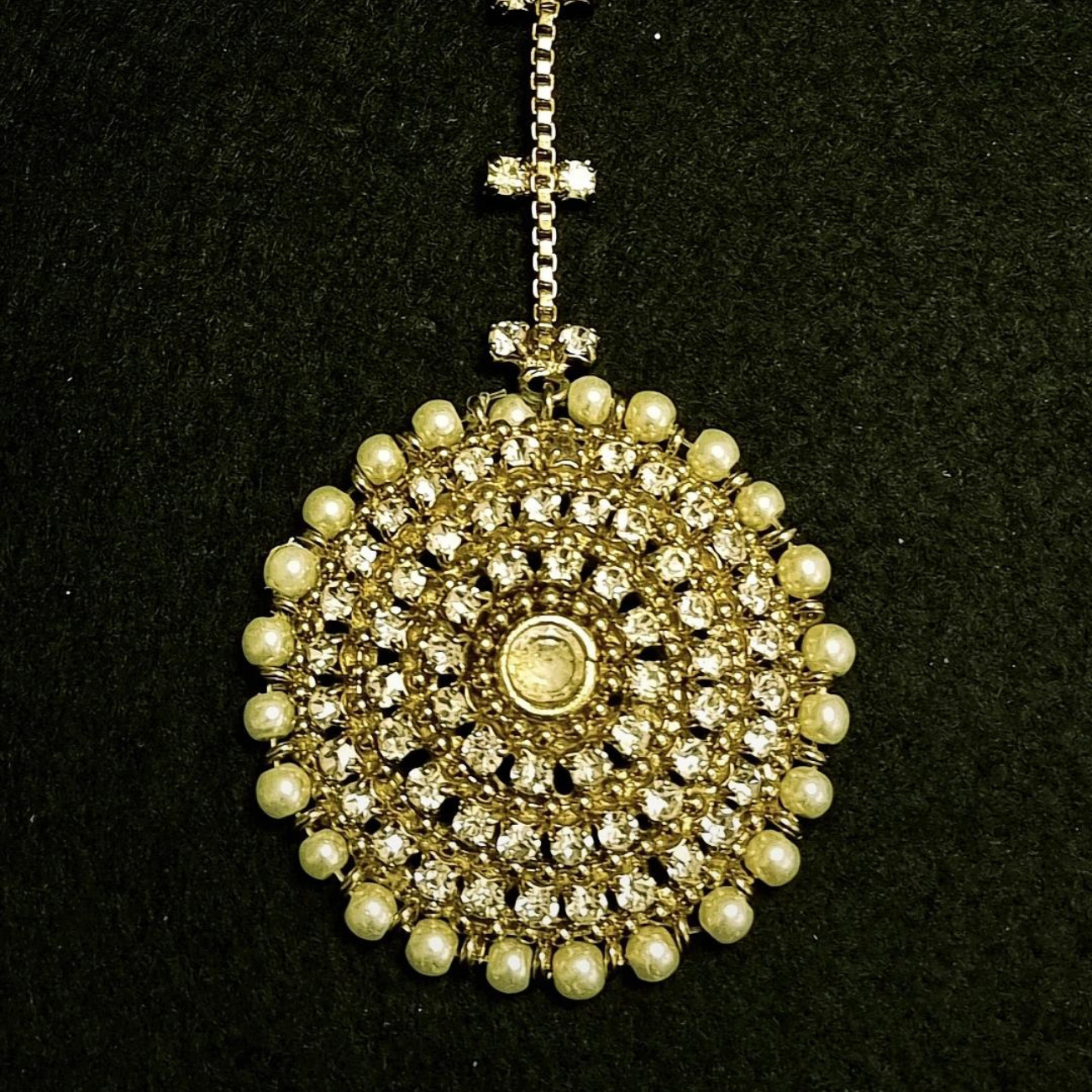 Stone studded with pearls maang tikka.